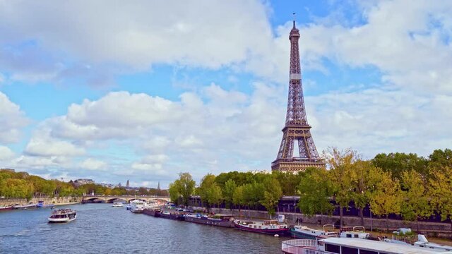 4K vedio of amazing view of the Eiffel tower from Bir-Hakeim bridge, over the river Seine , Paris, France. Paddle steamer and glass boats on river at a cloudy but sunny autumn day.