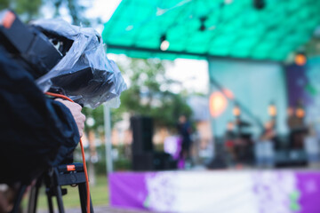 View of a camera man operator working during tv reportage, online broadcasting of concert, professional videographer with camera filming live event