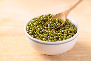 Mung bean with spoon in a bowl on wooden background