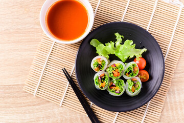 Colorful fresh vegetables salad spring roll eating with chili sauce, Healthy vegan food