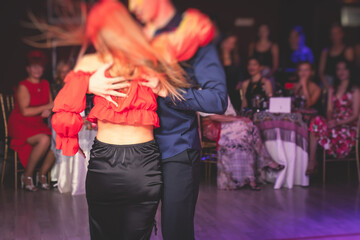 Couples dancing traditional latin argentinian dance milonga in the ballroom, tango salsa bachata lesson in the red lights, dance festival