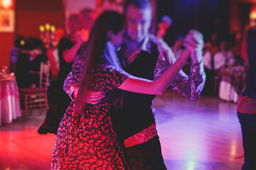 Couples dancing traditional latin argentinian dance milonga in the ballroom, tango salsa bachata...