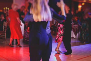 Couples dancing traditional latin argentinian dance milonga in the ballroom, tango salsa bachata lesson in the red lights, dance festival