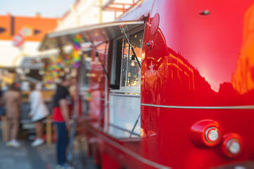 Girl ordering street food in colourful food truck van on food festival, summer sunny day