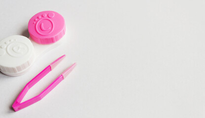 Contact lens, case and tweezers on gray background. Selective focus. Close up