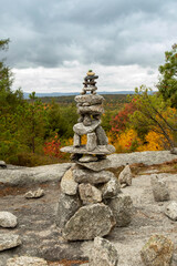 Cairn topped with a painted rock turtle guides hikers among the fall foliage of Pisgah State Park