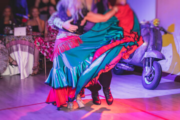 Couples and women wearing red skirts and dress dancing traditional gypsy dance in the ballroom hall