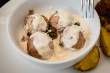 View of Koenigsberger klops,  a specialty traditional german style cooked meat balls in Kaliningrad, Kaliningrad Oblast, Russia, served with mashed potatoes in a white sauce with capers