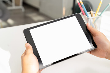 Closeup of woman hand holding digital tablet on the table and the screen is blank.