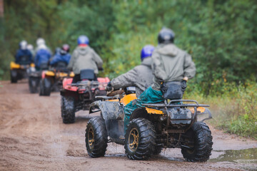 Group of riders riding atv vehicle on off road track, process of driving ATV vehicle, all terrain...