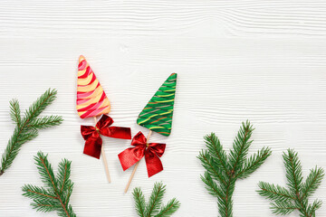 Christmas composition. Christmas sweets and candy canes, pine branches, New Year background, white table, top view, flat lay.