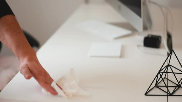 Man Wearing All Black Wipes  A White Trackpad On A White Desk