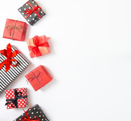 Top view of gift boxes wrapped in black and white striped, dotted and red paper over a white background. Various designs wrapped presents. Copy space
