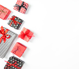 Top view of gift boxes wrapped in black and white striped, dotted and red paper over a white background. Various designs wrapped presents. Copy space