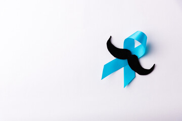 Black mustache paper and light blue ribbon, studio shot isolated on white background, Prostate...