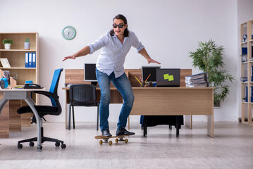 Young male employee with skateboard in the office