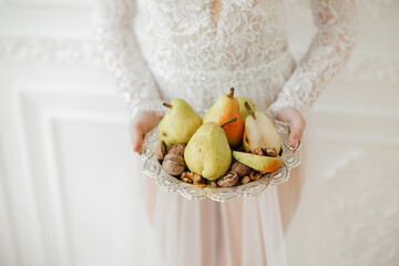 pears and nuts on beautiful plate in girls hands . High quality photo