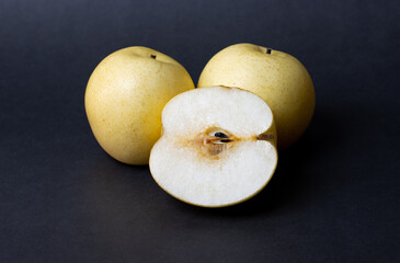 Isolated two rip pears with a pear slice on dark moody background