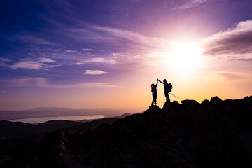happy couple man and woman tourist at top of mountain at sunrise a hike in summer