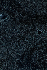 macro drops of blue coloron a black background