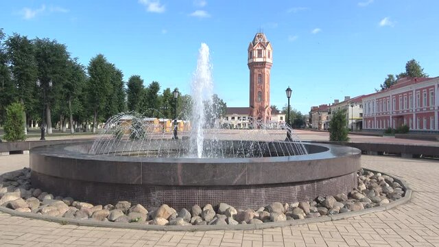 A fountain in the town square against the background of an old water tower. Staraya Russa, Russia  