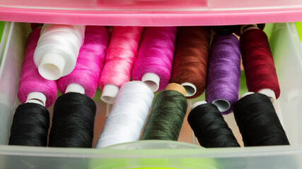 Many colourful thread spools in the box