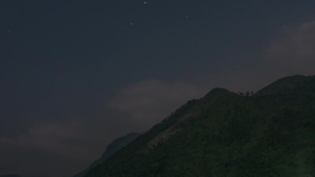 Night time time lapse of clouds moving fast near the mountains, Lanquin, Guatemala.
