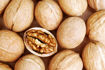 top view of shelled walnut between walnuts in shell background pattern
