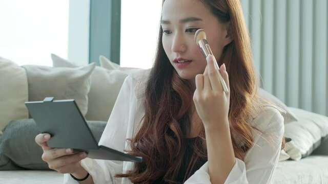 Portrait of young asian woman review giveaway gift product fan following channel, recording video make up lipstic cosmetic at home. Beauty blogger present beauty cosmetics