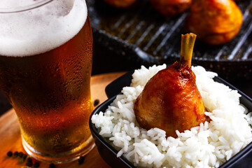 Rice with fried chicken and a glass of beer. Grill menu in a pub