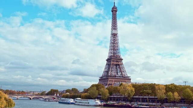 4K vedio of amazing view of the Eiffel tower from Bir-Hakeim bridge, over the river Seine , Paris, France. Paddle steamer and glass boats on river at a cloudy but sunny autumn day.