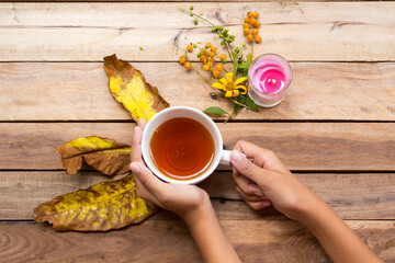 hand of girl holding herbal healthy drinks hot lemon tea for health care cough sore with flowers...