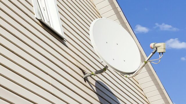 Satellite dish mounted on the wall of a private house.