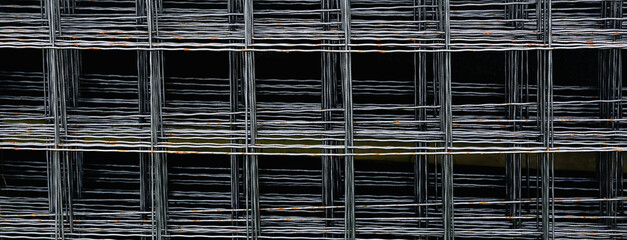 Reinforcement mesh is stacked for use in reinforced concrete construction work. Steel material in...