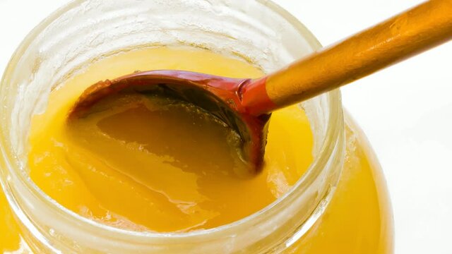 Natural floral honey in the pot on a white background.