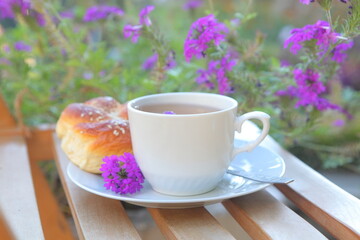 Obraz na płótnie Canvas cup of tea and bun on wooden table