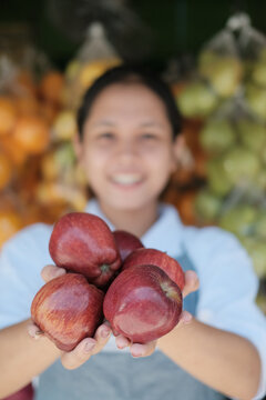 Fresh Red Apples In The Hands Of A Fruit Shop Clerk At A Fruit Stand