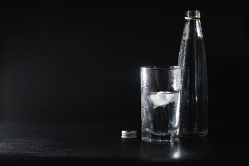 Close up pouring purified fresh drink water from the bottle on table in living room. Drinking water. Mineral vitamin water. Healthy, mineral-rich, refreshing water.