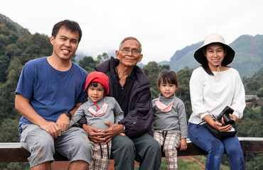 An Asian family happily photographed together in a tea plantation.