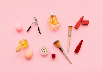 Set of makeup brushes with decorative cosmetics on color background