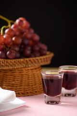 Red grape juice in glass with grape fruit