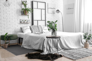 Interior of modern stylish bedroom with shelves and houseplants