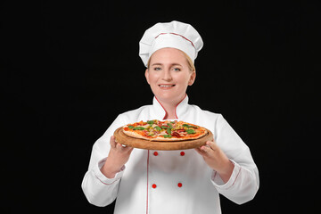 Mature female chef with tasty pizza on dark background
