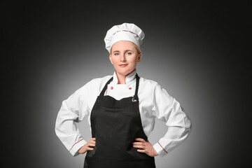 Mature female chef on dark background