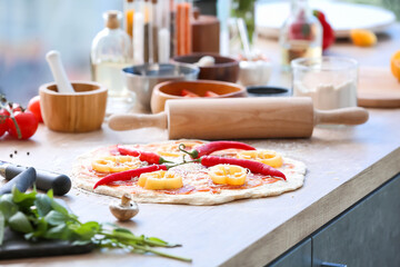 Raw pizza on kitchen table
