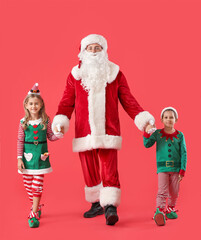 Cute little elves with Santa Claus on color background
