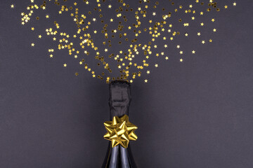 Celebration theme with champagne splashes on a black background with sequins. Christmas or New Year, background.