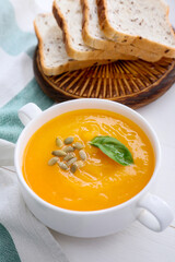 Tasty pumpkin cream soup in pot on table