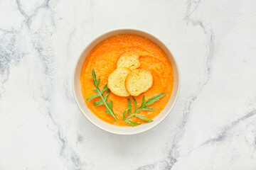 Tasty pumpkin cream soup in bowl on table