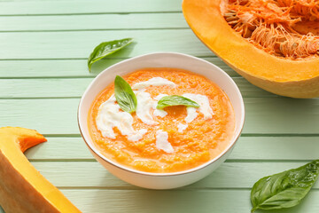Tasty pumpkin cream soup in bowl on table